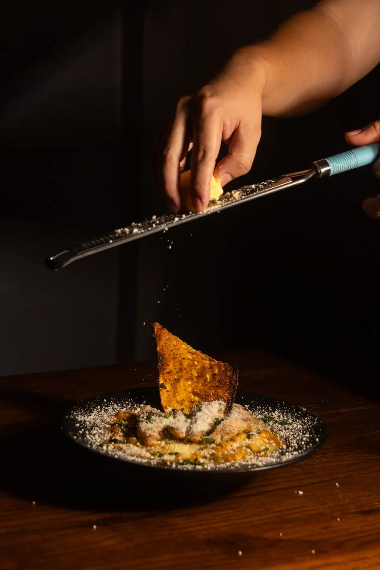 Fresh parmesan grated over pasta at Amerino